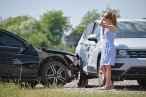 carro batido com motorista apreensivo ao lado