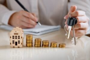 chave de casa com contrato e moedas