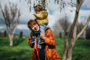 mae abracando crianca em parque ensolarado