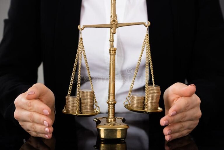 Como É Feito o Pagamento de Indenização por Danos Morais no Brasil 2 mao segurando moeda em balanca justica