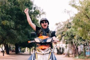 motociclista com capacete e maos levantadas