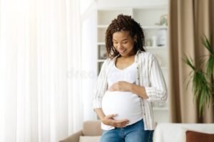 mulher gravida olhando janela esperancosa