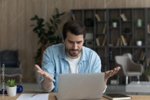 pessoa frustrada usando computador em casa