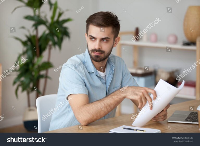 pessoa pensativa olhando documentos de trabalho