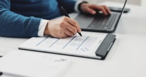 pessoa segurando atestado medico e laptop