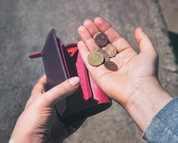 pessoa segurando carteira com moedas