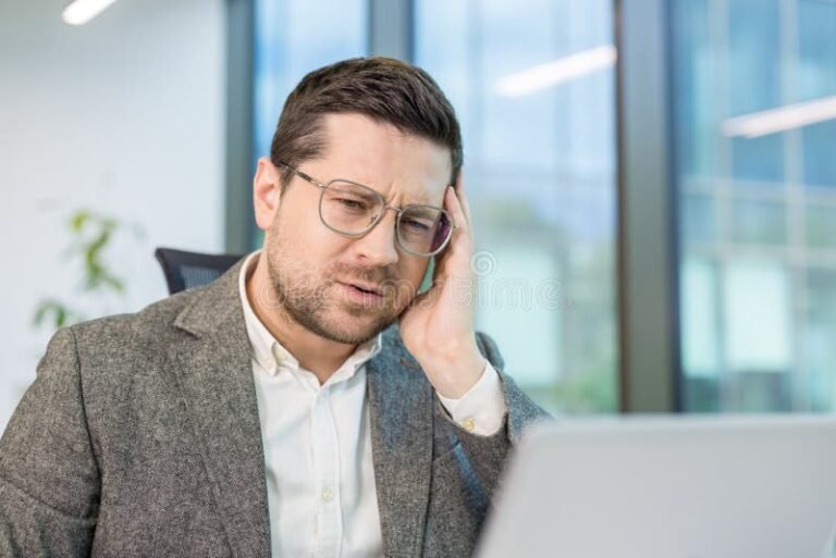 pessoa triste segurando a cabeca no escritorio